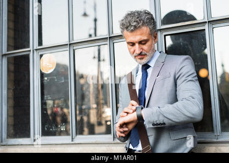 Mature businessman standing in a city. Stock Photo