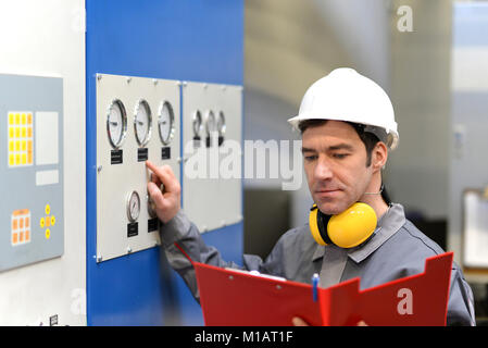 industrial workers inspect the technology of a plant for function - assembler in working clothes Stock Photo