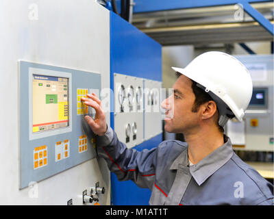 industrial workers inspect the technology of a plant for function - assembler in working clothes Stock Photo