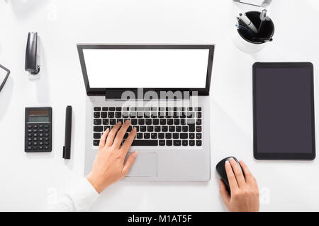 Close-up Of A Woman Working On Laptop On Desk At Workplace Stock Photo