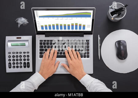 Close-up Of A Businesswoman Analyzing The Graph On Laptop At Workplace Stock Photo