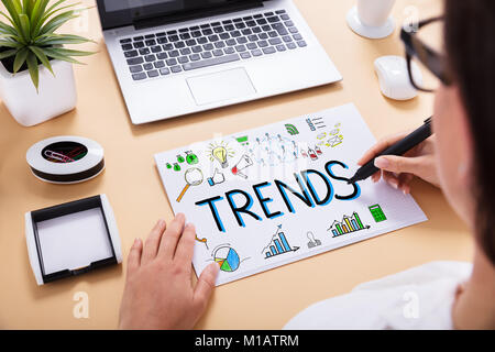 Close-up Of A Businessperson Drawing Trends Chart On Office Desk At Workplace Stock Photo