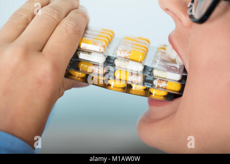 Close-up Of A Woman Putting The Capsules Blister Packs In Her Mouth Stock Photo