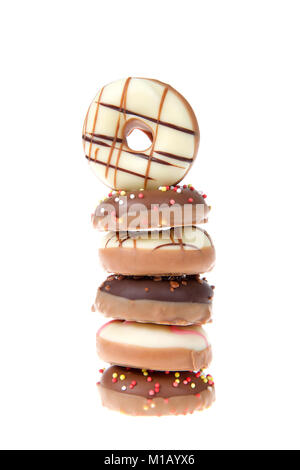 Miniature candy coated donuts decorated, in a single stack isolated on white, one fancy donut turned sideways facing viewer. Stock Photo