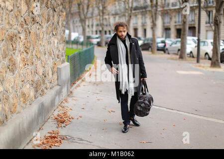 Sad mix blood man going to railway station and looking at watch. Stock Photo