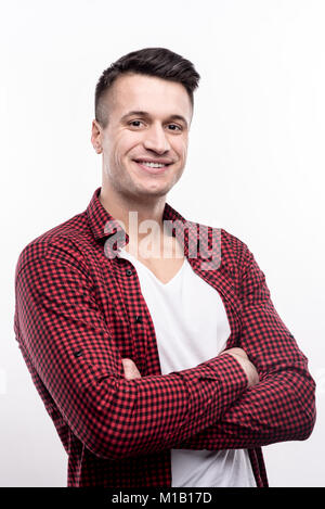 Charming man standing half-turned and folding his arms Stock Photo