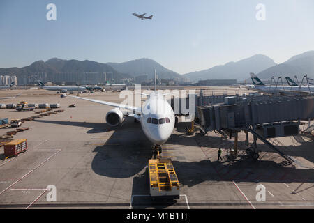 Airliners on the apron and taking off from Chek Lap Kok Airport, Hong Kong SAR, China. Stock Photo
