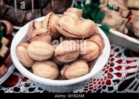 On the table on a lace napkin on a plate of delicious cookies in the shape of walnuts stuffed inside. Stock Photo