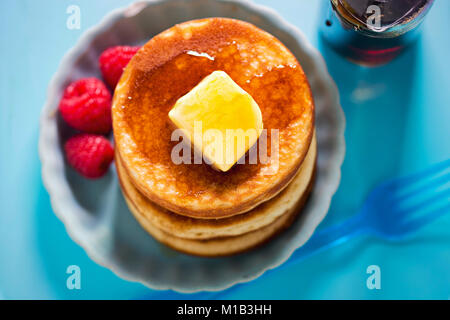 American pancakes with butter, maple syrup and raspberries Stock Photo