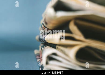 Newspapers on blue background with shallow depth of field Stock Photo