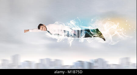 Hero superman flying above city with smoke left behind concept Stock Photo