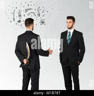 Ruthless businessman handshake with hiding a weapon and weapon symbols around his head Stock Photo