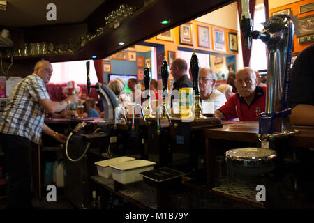 Locals at the Queens Head pub, Burlslem, Stoke-on Trent, watch the England World Cup match versus Slovenia, 23rd June 2010. Burslem was once the Mother town of the ceramic and pottery industry, but now only a few of the Pot Banks are fuctioning as most of the industry has moved to the far east. Rich Bowen Photography Stock Photo