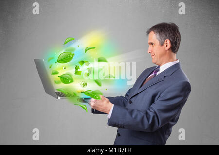 Handsome businessman holding laptop with recycle and environmental symbols Stock Photo