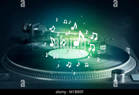 Turntable playing music with audio notes glowing concept on background Stock Photo