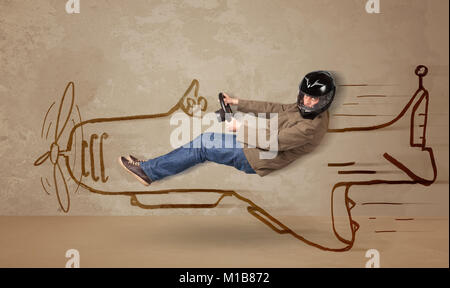 Funny pilot driving a hand drawn airplane on the wall concept Stock Photo
