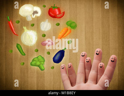 Happy smiley face fingers cheerfully looking at illustration of colorful healthy vegetables Stock Photo