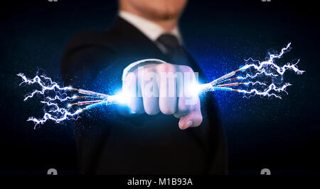 Business person holding electrical powered wires concept on background Stock Photo