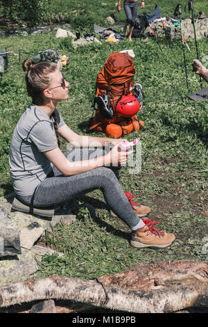 Girl in hiking boots, having fun and enjoying the rest at the camps admiring the nature. The concept of rest for a holiday in hikes, traveling lifesty Stock Photo