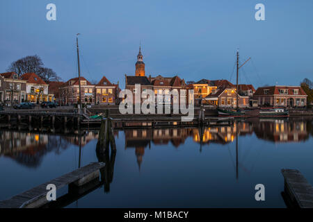 Blokzijl, The Netherlands - November 24, 2016: The harbor with two flat bottoms (ships) of Blokzijl in the province of Overijssel. With old monumental Stock Photo