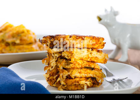 Stack of crispy waffle hash browns, or shredded potato pancakes, on a plate ready for a tasty breakfast in a low angle side view Stock Photo