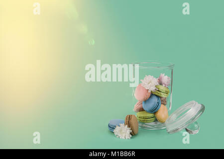 Fresh sweet colorful Macarons (Macaroons) in a glassy storage vessel with copy space Stock Photo