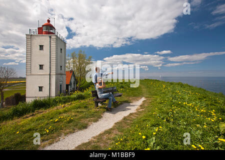The Netherlands, Oosterdijk, Couple, man and woman on bench near former lighthouse at lake called IJsselmeer. Stock Photo