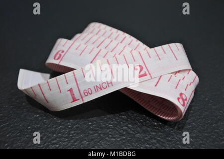 A folded measuring tape use by tailors and fashion designers. Stock Photo