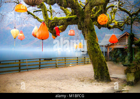 Surreal mysterious and dreamy landscape with magic lanterns on the old fairy tree in foggy winter weather Stock Photo
