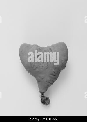 Deflate heart shape balloon in black and white isolated on white background Stock Photo