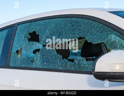 Vandalised car with a smashed broken window. Stock Photo