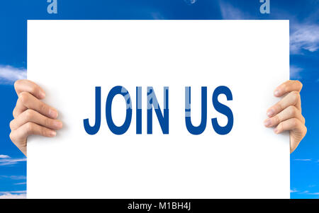 Hands holding a white board with the words join us, blue sky background Stock Photo