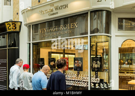 Peple looking at vintage watches through shop window of The Vintage Watch Company, Burlington Arcade, London, UK Stock Photo