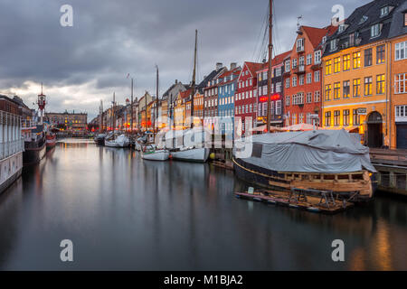 COPENHAGEN, DENMARK - FEBRUARY 28, 2017: Nyhavn at night. A 17th-century waterfront, canal and entertainment district with brightly colored townhouses Stock Photo