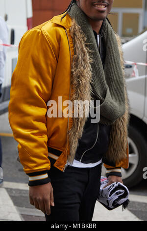 MILAN - JANUARY 15: Man with yellow bomber jacket with brown fur part and green scarf before Represent fashion show, Milan Fashion Week street style o Stock Photo