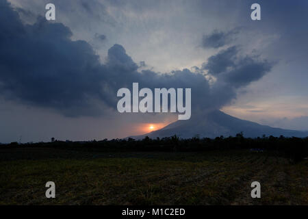 Colourful Sunset over Sinabung volcano in the Karo Highlands of North Sumatra, Indonesia. This is a highly active volcano. Stock Photo