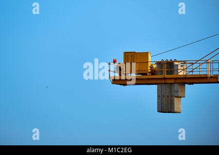 Part of yellow construction tower crane arm against the blue sky Stock Photo