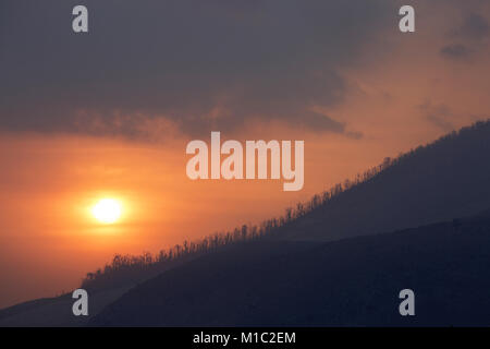 Colourful Sunset over Sinabung volcano in the Karo Highlands of North Sumatra, Indonesia. This is a highly active volcano. Stock Photo