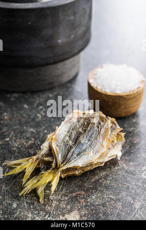 Dried salted fish on old kitchen table. Stock Photo