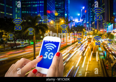 5G or LTE presentation. Woman hand using smartphone with modern city on the background Stock Photo
