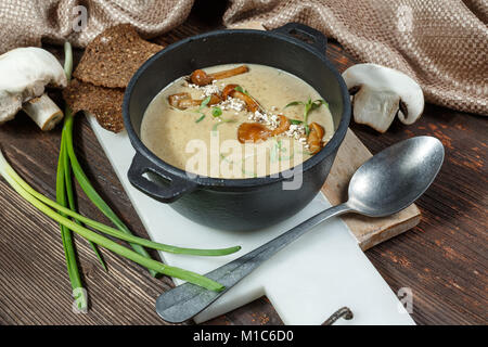 Cream soup with mushrooms and fresh chanterelles mushroom on wooden rustic background Stock Photo