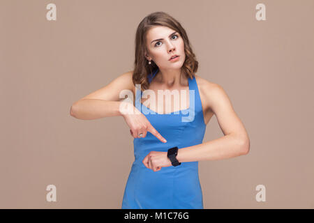 Rage boss pointing at her watch and looking at camera. Studio shot Stock Photo