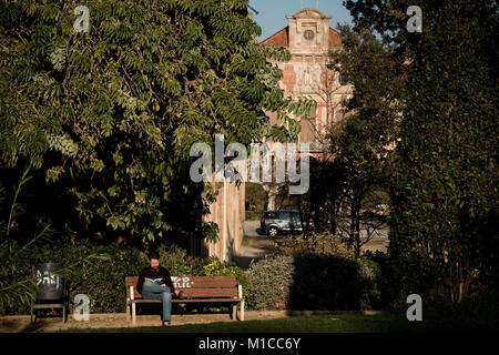 January 29, 2018 - Barcelona, Catalonia, Spain -  In Barcelona a man reads a book at Ciutadella park with  the Catalan Parliament building on the background  hours prior to the Catalonia President investiture debate. The Catalan Parliament  convened the debate on investing Carles Puigdemont as president of Catalonia for Tuesday 30th January. The announcement came despite threats from the Spanish government that they would challenge a potential Puigdemont candidacy to Spain's Constitutional Court. Stock Photo