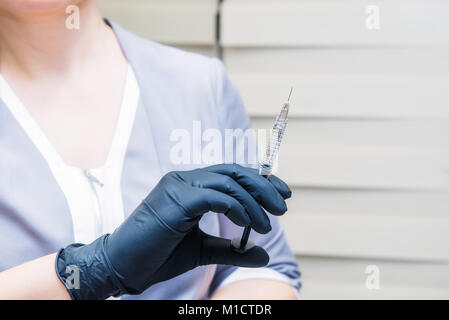 Dermatologist doctor with syringe planning beauty facial injections. Face aging, rejuvenation, mesotherapy and hydration procedures. Aesthetic cosmetology. Selective focus. Stock Photo