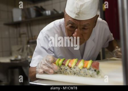 Senior chef preparing sushi in kitchen