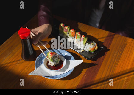 Woman having sushi food in restaurant Stock Photo