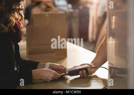 Woman making payment through mobile phone Stock Photo