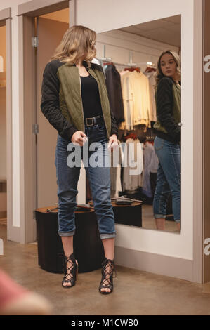 Beautiful woman checking jacket in front of the mirror Stock Photo