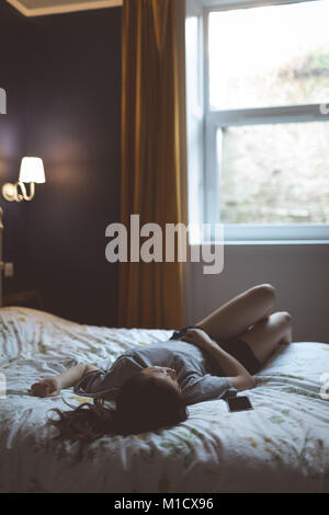 Woman sleeping in bedroom Stock Photo