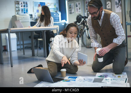 Executives discussing over blueprint Stock Photo